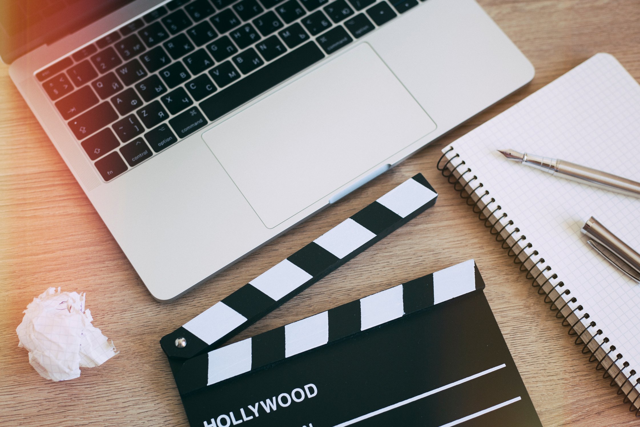 Video Editing,Movie clapper laptop and pencil notepad on the wood table top view